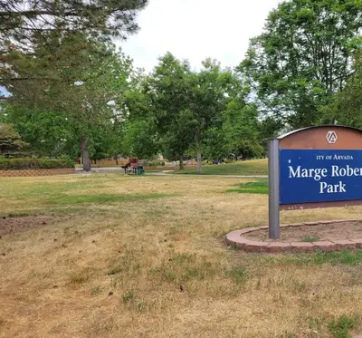 a sign in a park with a park bench in the background at Close to Downtown Sleeps 8 Private Backyard in Arvada