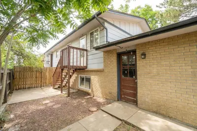 a brick house with a wooden door and a staircase at Close to Downtown Sleeps 8 Private Backyard in Arvada