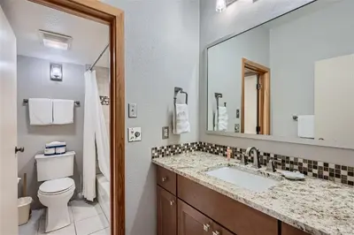 a bathroom with a sink and a toilet and a mirror at 2151 The Pines condo in Keystone