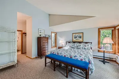 a bedroom with a bed with a blue bench in it at 2151 The Pines condo in Keystone