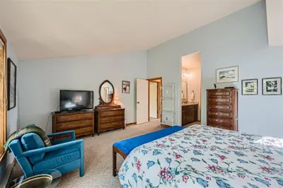 a bedroom with a bed and a tv and a chair at 2151 The Pines condo in Keystone