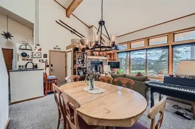 a dining room with a table and a piano at 2151 The Pines condo in Keystone