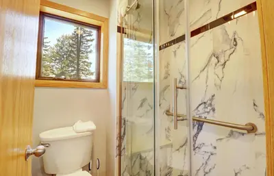 a bathroom with a toilet and a glass shower at 195 Summerwood home in Dillon