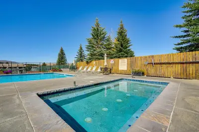 a swimming pool in a yard next to a wooden fence at 6 Mi to Winter Park Resort Fraser Condo with Pool in Fraser