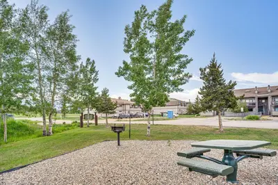 a picnic table and benches in a park at 6 Mi to Winter Park Resort Fraser Condo with Pool in Fraser