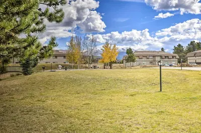 a large field with a building in the background at 6 Mi to Winter Park Resort Fraser Condo with Pool in Fraser