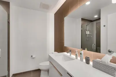 a bathroom with a sink and a toilet and a mirror at Modern Elegance on Linden - Walk, Bike Everywhere! in Fort Collins