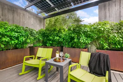 a patio with two chairs and a table on a deck at Modern Elegance on Linden - Walk, Bike Everywhere! in Fort Collins