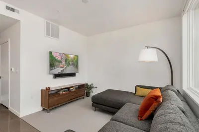 a living room with a couch and a flat screen tv at Modern Elegance on Linden - Walk, Bike Everywhere! in Fort Collins
