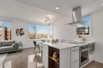 a kitchen and living room with a sink and a stove at Modern Elegance on Linden - Walk, Bike Everywhere! in Fort Collins