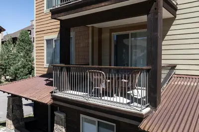 a balcony of a house with two chairs on it at Trailhead Lodge 621 condo in Winter Park