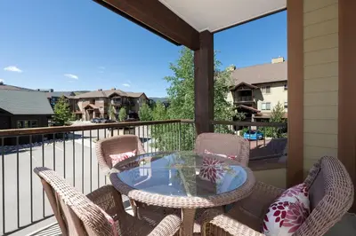 a patio with a glass table and chairs on a balcony at Trailhead Lodge 621 condo in Winter Park