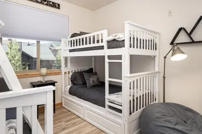 a bedroom with two bunk beds and a window at Trailhead Lodge 621 condo in Winter Park