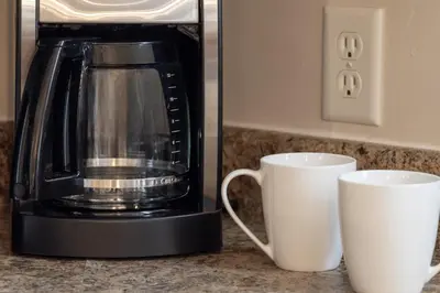 a coffee maker and two cups on a counter at Trailhead Lodge 621 condo in Winter Park