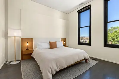 a bedroom with a large bed and two windows at NEW! Modern Scandinavian Loft in Old Town Square in Fort Collins