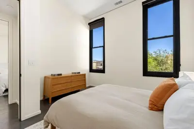 a bedroom with a bed and two windows at NEW! Modern Scandinavian Loft in Old Town Square in Fort Collins