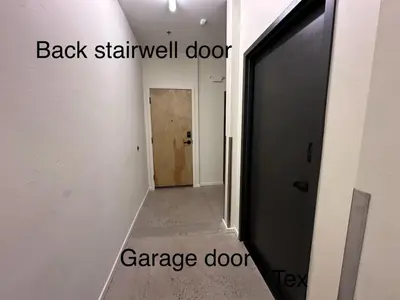 a hallway with a black door and a garage door at NEW! Modern Scandinavian Loft in Old Town Square in Fort Collins