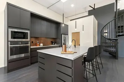 a kitchen with black cabinets and a white counter top at NEW! Modern Scandinavian Loft in Old Town Square in Fort Collins