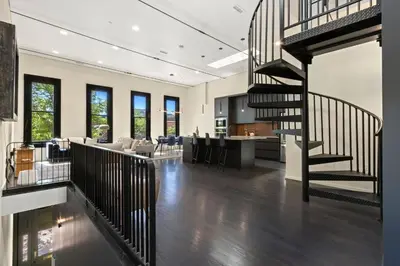a living room and kitchen with a spiral staircase at NEW! Modern Scandinavian Loft in Old Town Square in Fort Collins
