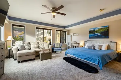 a bedroom with a blue bed and a couch at 2782 Slopeside condo in Keystone