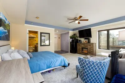 a bedroom with a blue bed and a couch at 2782 Slopeside condo in Keystone