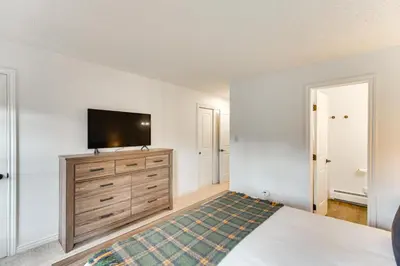 a bedroom with a bed and a television on a dresser at Hike, Bike, Ski Winter Park Condo with Deck in Winter Park