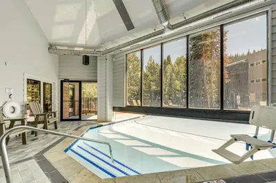 a swimming pool in a house with windows at Cozy Ski-InandSki-Out Winter Park Condo with Pool! in Winter Park