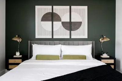 a bedroom with green walls and a bed with two lamps at Serenity in Style | Espadin LoHi in Denver
