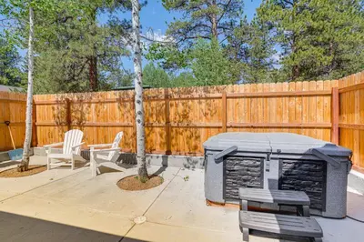 a grill and chairs on a patio with a fence at Patio and Hot Tub Cozy Cabin Retreat in Bailey! in Bailey