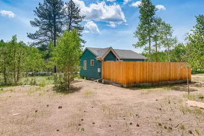 a house in a yard with a fence at Patio and Hot Tub Cozy Cabin Retreat in Bailey! in Bailey