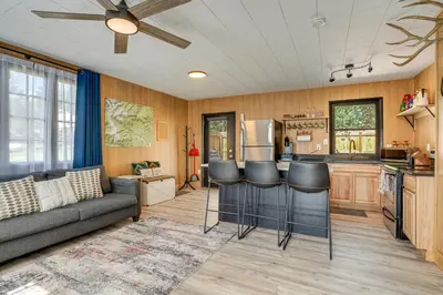 a living room with a couch and a kitchen at Patio and Hot Tub Cozy Cabin Retreat in Bailey! in Bailey