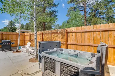 a hot tub on a patio next to a wooden fence at Patio and Hot Tub Cozy Cabin Retreat in Bailey! in Bailey