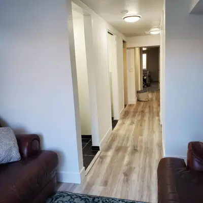 a living room with a couch and a hallway at 7 bedroom 8 beds family house in Denver