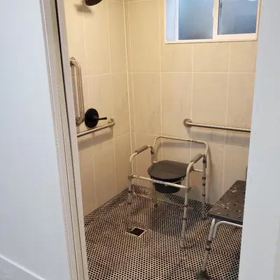 a bathroom with a chair in a shower at 7 bedroom 8 beds family house in Denver