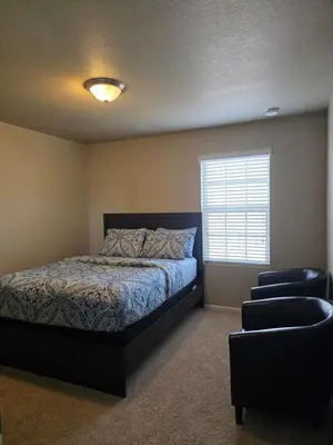 a bedroom with a bed and a chair and a window at Humble Home in Aurora