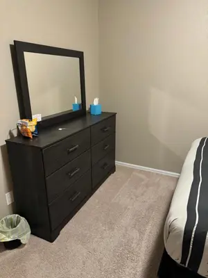 a bedroom with a dresser with a mirror on it at Humble Home in Aurora