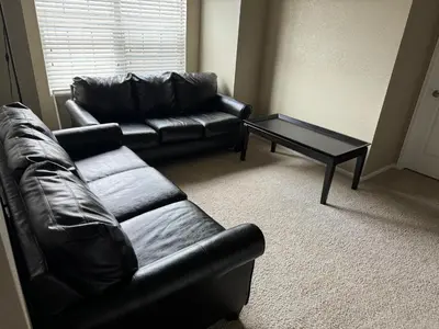 a living room with a leather couch and a coffee table at Humble Home in Aurora