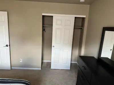 a bedroom with two white doors and a closet at Humble Home in Aurora