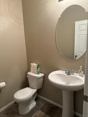 a bathroom with a toilet and a sink and a mirror at Humble Home in Aurora