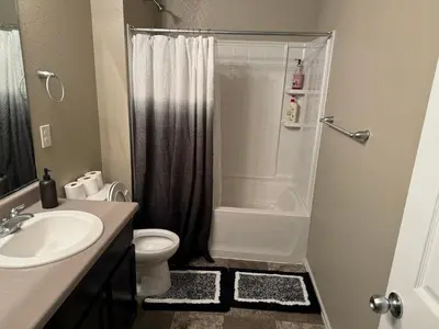 a bathroom with a shower and a toilet and a sink at Humble Home in Aurora