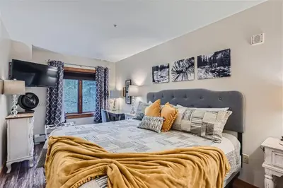 a bedroom with a large bed with orange pillows at 2225 Red Hawk condo in Keystone