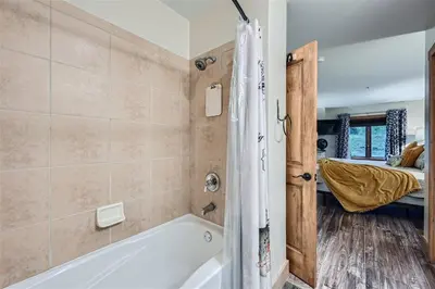 a bathroom with a bath tub and a bedroom at 2225 Red Hawk condo in Keystone