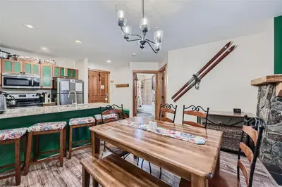 a kitchen and dining room with a wooden table and chairs at 2225 Red Hawk condo in Keystone
