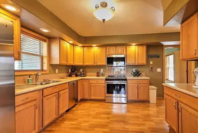 a kitchen with wooden cabinets and a stove top oven at Evergreen Ranch Family Vacation Home, Sleeps 8, Private Hot Tub in Granby