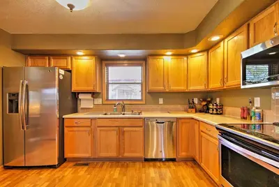 a kitchen with wooden cabinets and a stainless steel refrigerator at Evergreen Ranch Family Vacation Home, Sleeps 8, Private Hot Tub in Granby