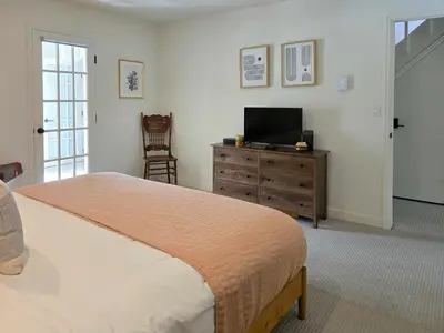 a bedroom with a bed and a television on a dresser at The Rail Haven townhouse in Winter Park