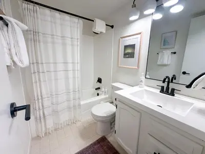 a white bathroom with a sink and a toilet at The Rail Haven townhouse in Winter Park