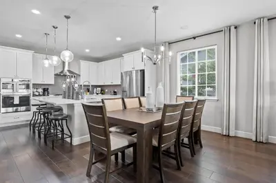 a kitchen and dining room with a wooden table and chairs at Ouray Street - Commerce City in Henderson
