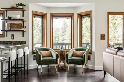 a kitchen with green chairs and a table in front of windows at Hot Tub - Scenic Views - Spacious Deck - Game Room in Evergreen