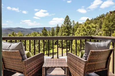 a balcony with chairs and a table and a view of the mountains at Hot Tub - Scenic Views - Spacious Deck - Game Room in Evergreen
